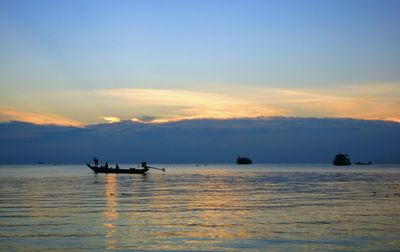 Silhouette boats in sea against sky during sunset