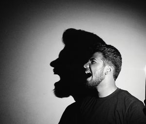 Young man shouting against wall