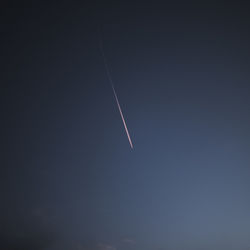 Low angle view of vapor trail against clear sky at night