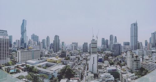 Aerial view of buildings in city against sky