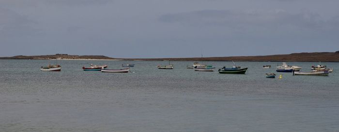 Boats moored on sea against sky