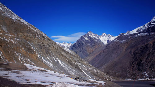 Scenic view of snowcapped mountains against blue sky