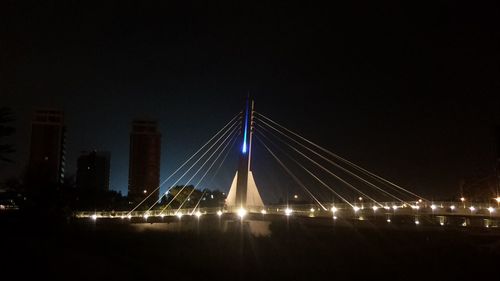 Suspension bridge over river at night