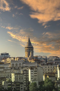 Buildings in city against sky during sunset