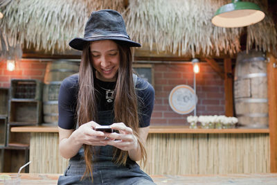 Portrait of smiling young woman using mobile phone