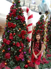 Full length of woman with red christmas tree