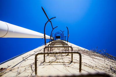 Low angle view of windmill against clear blue sky