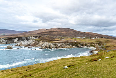 Scenic view of sea and mountains against sky