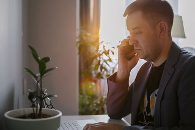 Young man using mobile phone at home