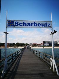 Information sign on bridge against sky