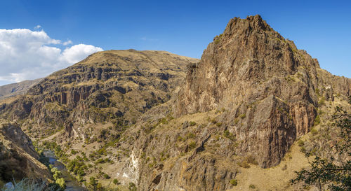 Low angle view of rocks on mountain against sky