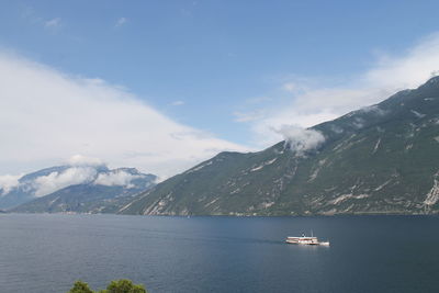 Scenic view of sea by mountains against sky