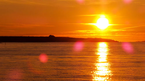 Scenic view of sea against romantic sky at sunset