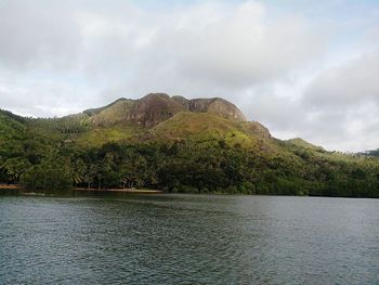 Scenic view of lake by trees against sky