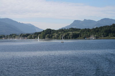 View of calm sea against mountain range