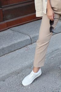 Low section of woman standing on street