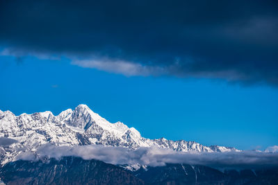 Scenic view of snowcapped mountains against blue sky