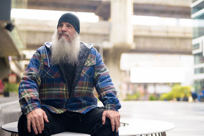 Portrait of man sitting in city