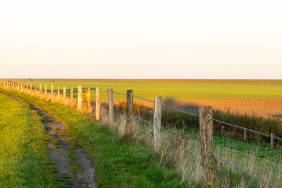 Fence on field against clear sky