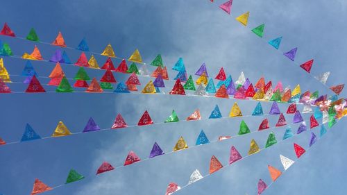 Low angle view of multi colored flags against sky