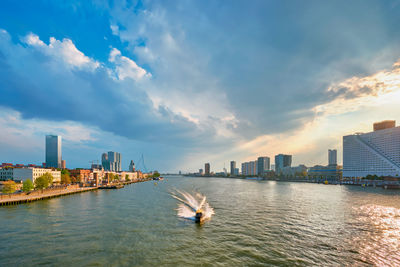 River amidst buildings in city against sky