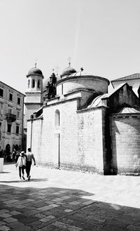 People walking in temple against clear sky