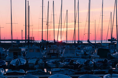 Boats moored at harbor during sunset