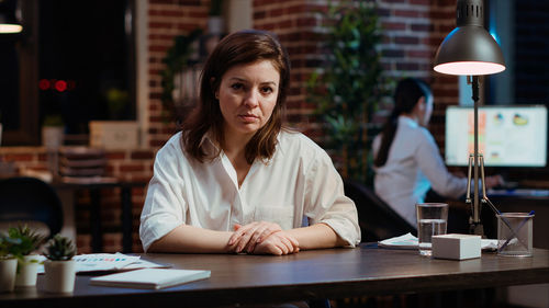 Portrait of young businesswoman working at desk in cafe