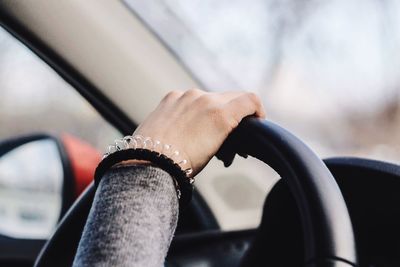 Cropped hand of woman driving car