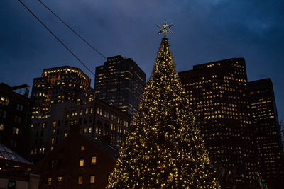 Low angle view of illuminated buildings against sky at night