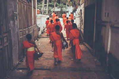 People walking on street amidst buildings in city