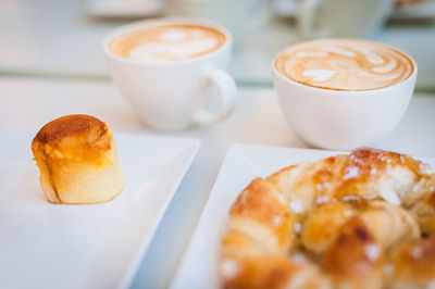 High angle view of dessert with cappuccinos and croissant served on table