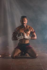 Portrait of fighter kneeling in temple