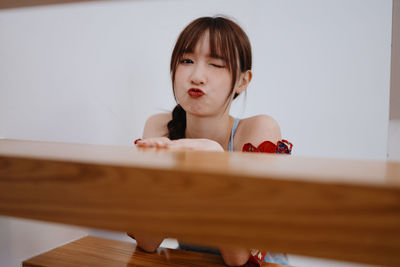 Portrait of young woman sitting on table