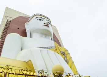 Low angle view of statue against building against sky