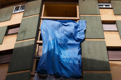 Low angle view of blue plastic curtain against building