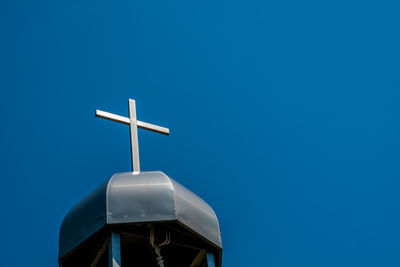 Low angle view of cross against clear blue sky