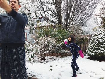 Full length of woman standing on snow covered tree