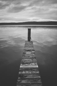 Wooden pier on lake against sky