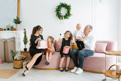 Happy family with cute children wear christmas tree together at home celebrate christmas 