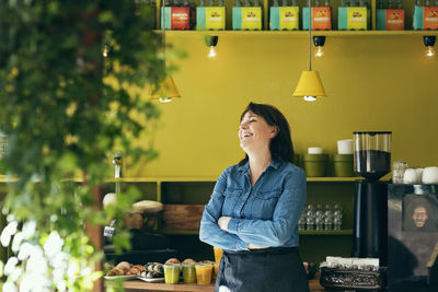 Smiling female owner standing in cafe