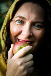 Close-up portrait of a woman eating a apple 