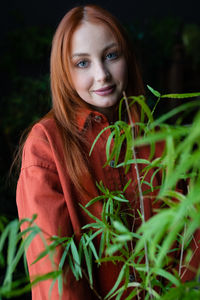 Portrait of young woman with eyes closed against plants
