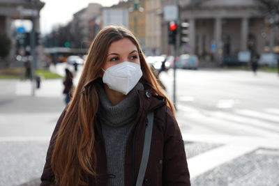 Woman wearing mask sanding on street