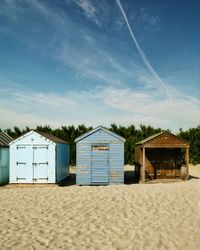 Hut on beach against blue sky