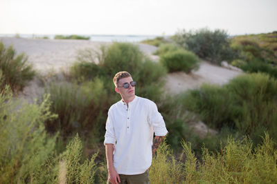 Portrait of young man standing on field