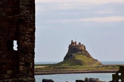 View of historic building by sea against sky