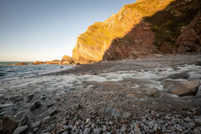 Long exposure of the river heddon flowing onto the beach at heddons mouth in exmoor