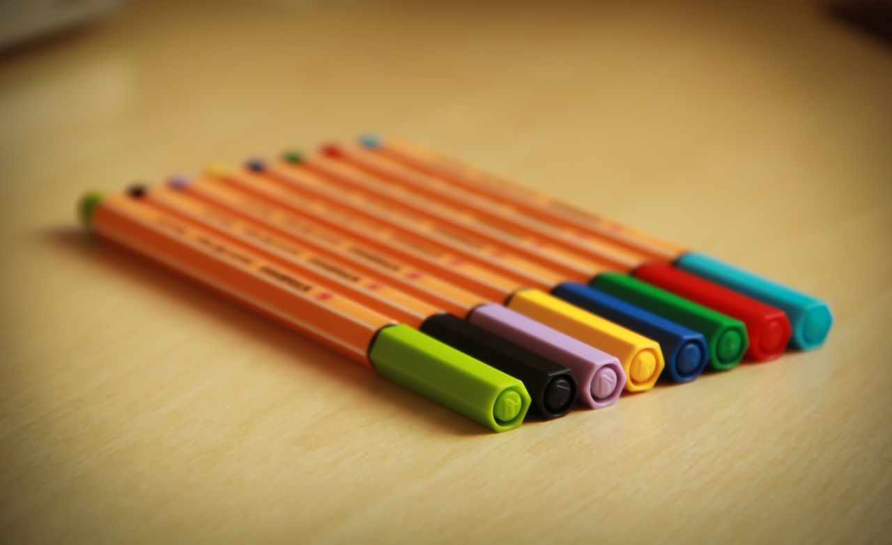 indoors, multi colored, still life, variation, table, in a row, pencil, arrangement, close-up, selective focus, large group of objects, choice, colored pencil, colorful, wood - material, order, education, no people, high angle view, pen