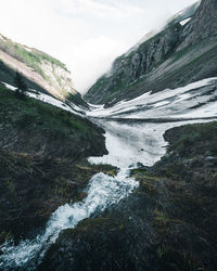 Scenic view of river and mountains against sky